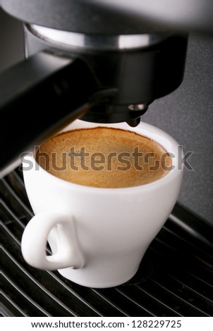 white cup filled with coffee in the coffee machine