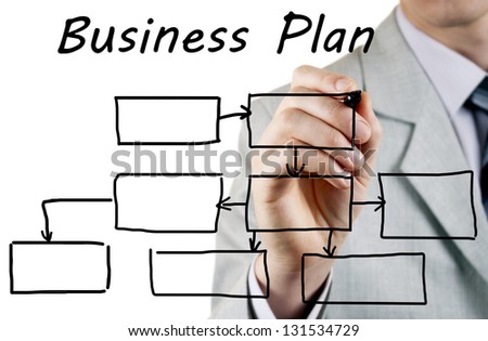 man in a business suit makes a block diagram on a blackboard