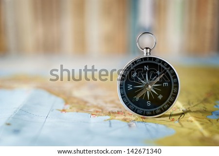 compass on the map and book in the background in the area of confusion