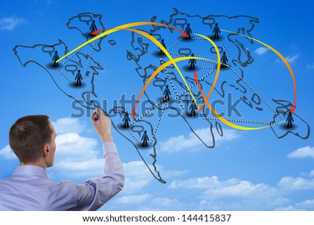 Man illustrating world population migration diagram on a glass wall, with his back to the camera.