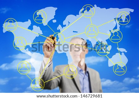 Businessman sketching a global business or social network on a world map superimposed over a blue sky