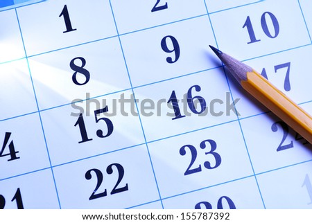Pencil lying on a calendar showing different dates and days conceptual of schedules, time management, events, deadlines and organisation