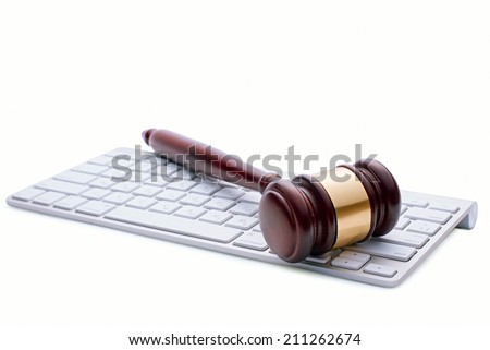 Wooden gavel on a white computer keyboard conceptual of online auctions or law enforcement and justice over the internet and punishment of cyber crime, on a white background