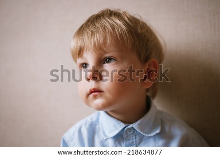 Portrait of Young Boy Wearing Bow Tie Against Plain Wall with Copyspace