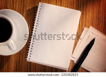 Grid Notebook and Pen with Cup of Coffee on Desk as seen from Above
