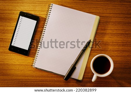 Organizer and Grid Notebook with Cup of Coffee on Desk as seen from Above