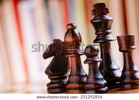 Close up Glossy Black Wooden Chess Pieces- King, Bishop, Knight, Rock and Pawn, Standing on Chess Board.