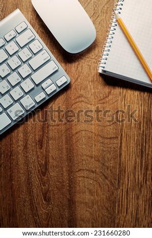 Close up Computer Keyboard and Mouse , Pencil and Graphing Notebook on Top of Wooden Desk with Copy Space .