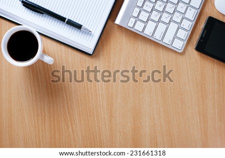 Close up Wooden Table of Businessman with Notebook and Pen, Computer Keyboard, Mobile Phone and A Cup of Black Coffee to Stay as Stress Reliever.