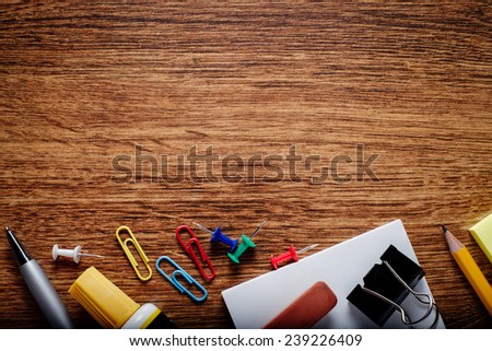Various Office Supplies on Wooden Table, Captured at the Bottom Edge of the Frame, with Copy Space on Top for Texts.