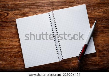 Conceptual Open Spiral Graphing Notebook and Pen on Brown Wooden Table with Copy Space for Texts.