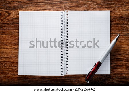 Conceptual Open Spiral Graphing Notebook and Pen on Brown Wooden Table with Copy Space for Texts.
