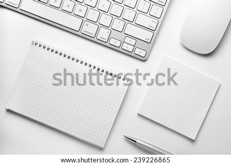 Conceptual White Spiral Notebook, Sticky Notes and Pen with Computer Keyboard and Mouse on White Table, Emphasizing Copy Space for Texts.