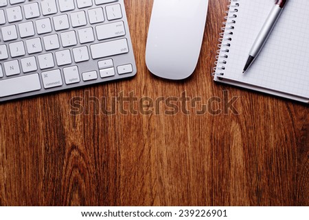Conceptual Ballpoint Pen and White Computer Keyboard and Mouse on Top of Wooden Table with Copy Space.