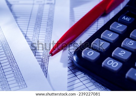 Close up Black Calculator and Red Pen on Top of Paper Reports with Numerical Prints. Emphasizing Business Sales Concept.