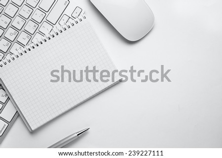 Conceptual White Ballpoint Pen, Clean Spiral Notes, Computer Keyboard and Mouse on Top of White Table with Copy Space at the Center.