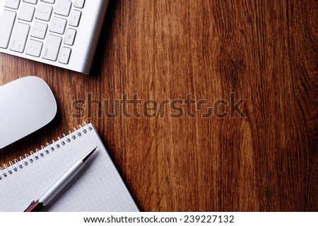 Conceptual Ballpoint Pen and White Computer Keyboard and Mouse on Top of Wooden Table with Copy Space.