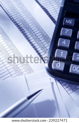 Business Concept - Close up Black Calculator and Ballpoint Pen on Top of Sales Invoice Reports.