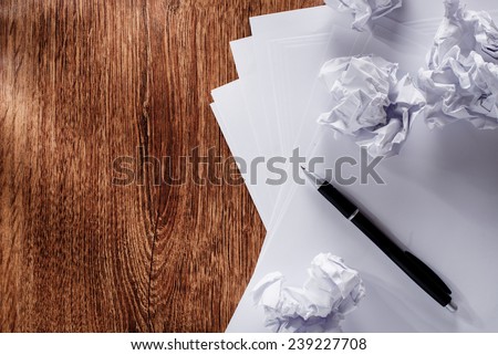Close up Blank White Documents and Crumpled Papers with Black Pen on Wooden Table with Copy Space on the Left Side.