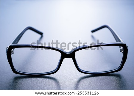 Horn-rimmed glasses with reflection on blue background
