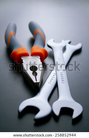 Close up Combination Pliers and Open Ended Wrenches Hand Tools on a Gray Background