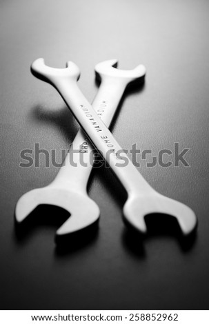 Two chrome vanadium spanners or wrenches with boxing ends lying on a dark background, low angle view in a DIY, renovation and maintenance concept
