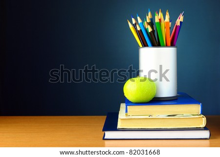 pencils and books on the table against the wall of blue