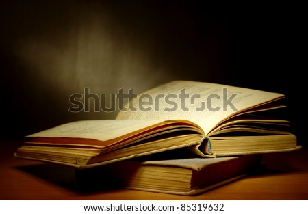 old book on a dark background and light beam