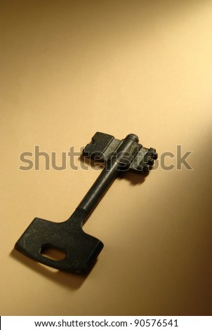 the old key on yellow paper illuminated by a beam of light