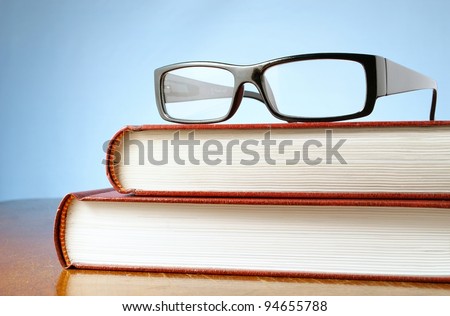 book and black-rimmed glasses on a table