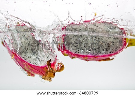 Exotic Dragon fruit dropped into water isolated on white.
