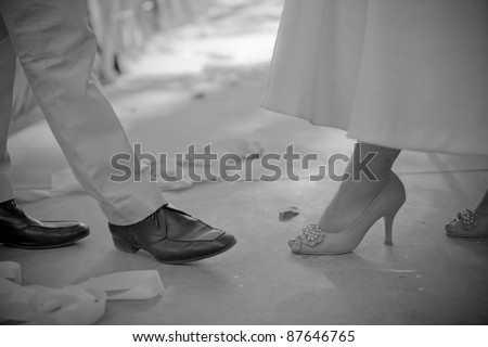 Bride and groom couple dancing showed legs/shoes black and white.