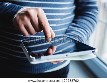 The Man Uses A Tablet Pc. Modern Gadget In Hand.