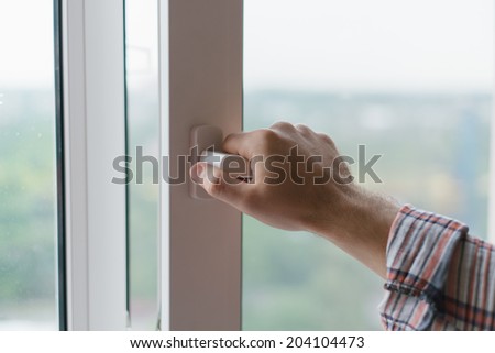 Male hand opens a window