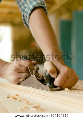 carpenter working with plane on wooden background carpenter working with plane on wooden background