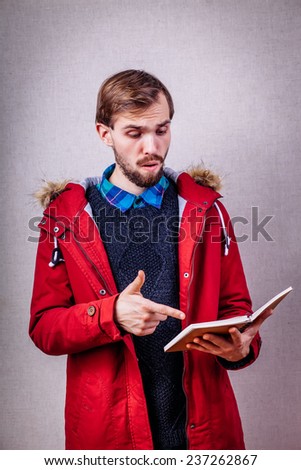 Closeup portrait of surprised young, handsome man reading book. man reading book