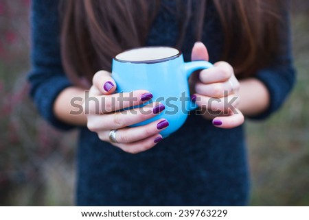 Woman with big mug of hot drink during cold day.