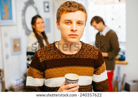 Portrait of handsome guy drinking coffee in home kitchen
