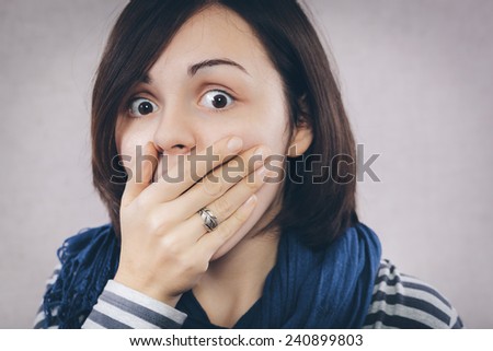 Surprised woman with hand over her opened mouth and big eyes