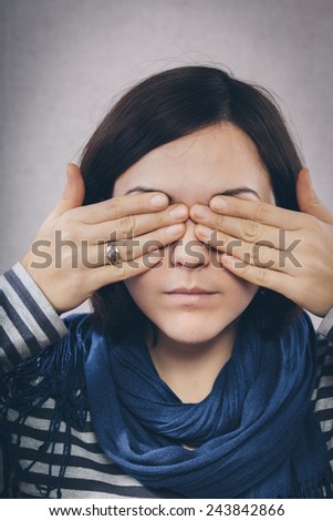 young woman covering her eyes with hands