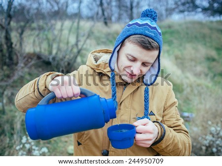 Man pouring tea at outdoors in autumn