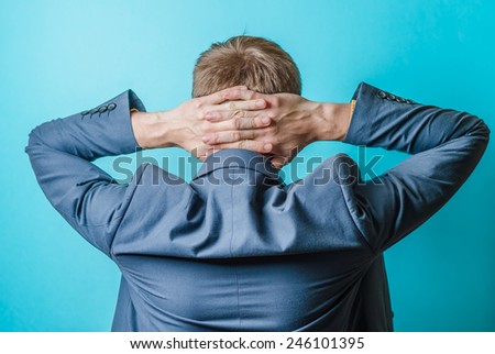 back view picture of a young business man scratching his head