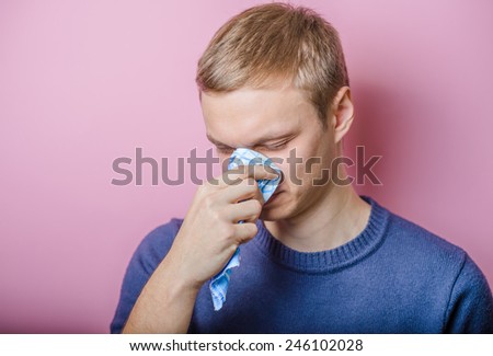 Young man close-up , cold, cold, blowing his nose in the handkerchief. Mimicry. Gesture. photo Shoot