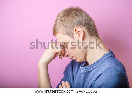 Closeup side view of a tired young businessman staring into space against white background