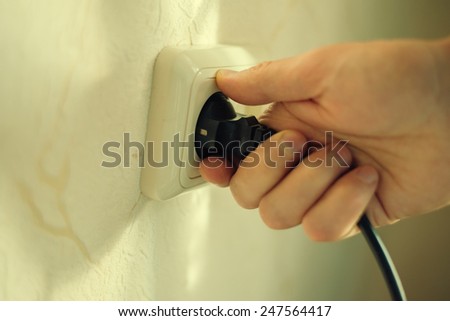 Plug in hand and socket. Close up