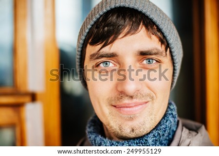 Casual young man looking at camera satisfaction in a hat
