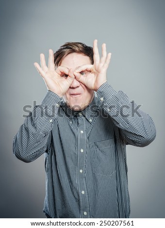 Funny man with hand over eyes, looking through fingers