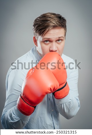 Portrait of young man in red boxing gloves fighting