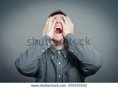 Portrait of a young man shouting loud with hands on the mouth, isolated on white background