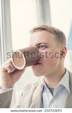 Successful business man is drinking a cup of coffee